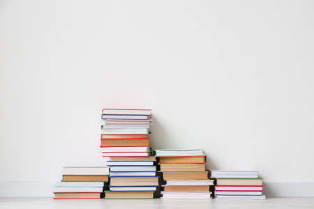 Stack of books near light wall in roomの写真素材
