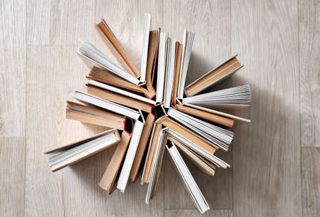 Stack of books on light wooden backgroundの写真素材