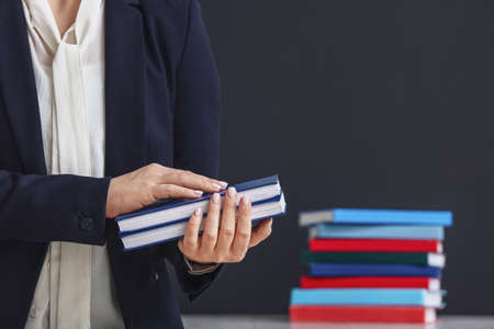 Female teacher with books in classroom, closeupの写真素材