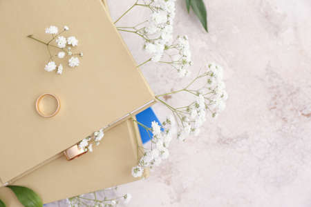 Books with fresh flowers and golden rings on grunge background