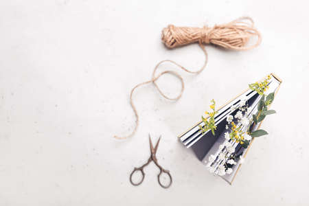 Book with fresh flowers, threads and scissors on white backgroundの写真素材
