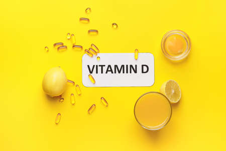 Text VITAMIN D and different healthy products on yellow background
