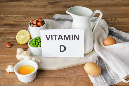 Text VITAMIN D and different healthy products on wooden backgroundの写真素材