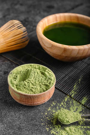 Bowl with matcha tea, powder and chasen on dark backgroundの写真素材