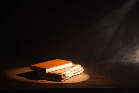 Old books on table against dark background