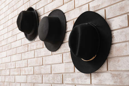 Stylish hats on light brick backgroundの写真素材