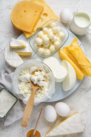 Different dairy products and chicken eggs on light background