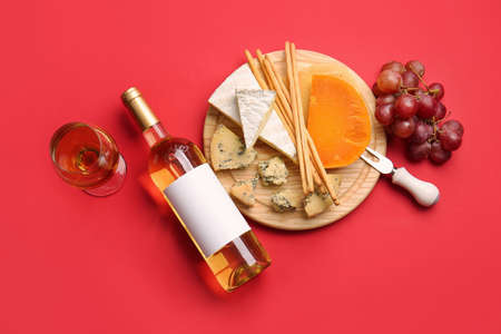 Composition with bottle of wine and snacks on color backgroundの写真素材