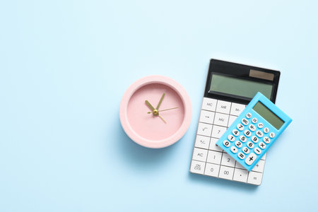Alarm clock with calculators on color backgroundの写真素材