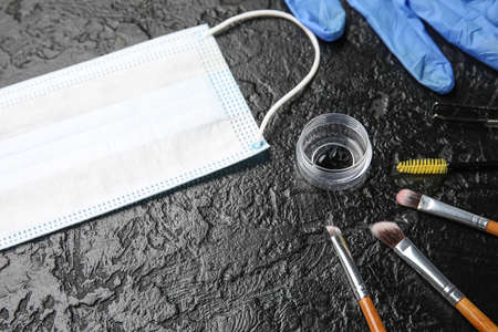 Henna, tools for eyebrows correction, mask and glove on dark background, closeup