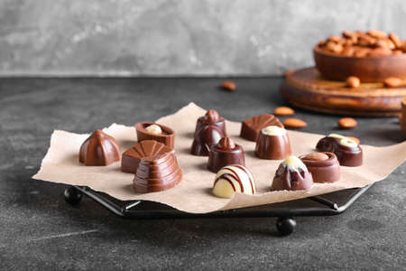 Parchment with tasty chocolate candies on dark background