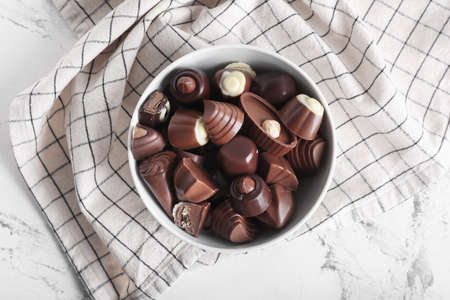 Bowl with tasty chocolate candies on tableの写真素材
