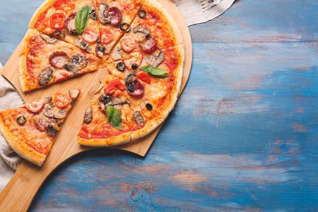 Board with tasty pizza on color wooden backgroundの写真素材