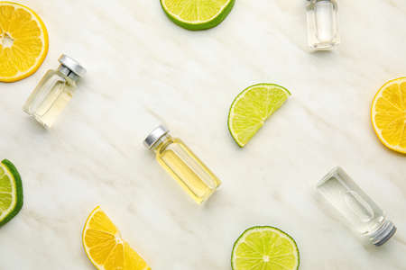 Bottles with vitamin C and citrus fruits slices on light backgroundの写真素材