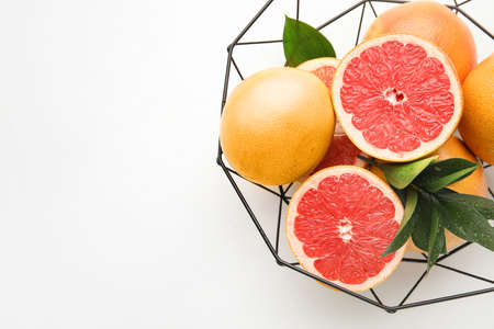 Basket with fresh cut grapefruits on white backgroundの写真素材