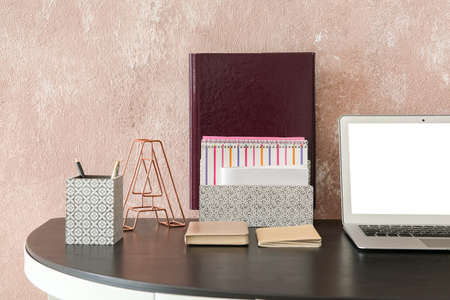 Modern workplace with organizer and laptop in room