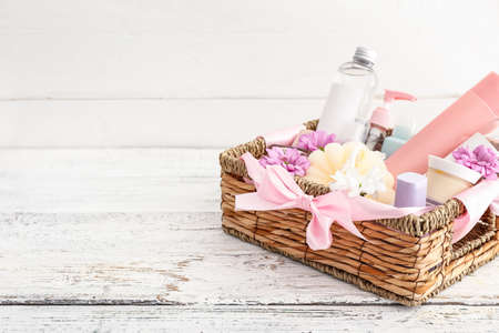 Gift basket with cosmetics on light wooden backgroundの写真素材