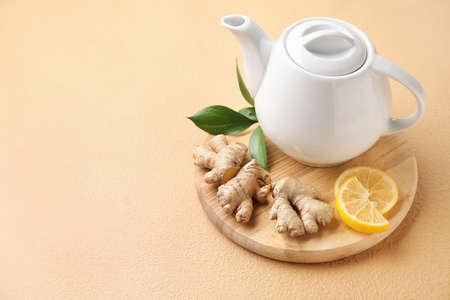 Composition with teapot of tasty ginger tea on color backgroundの写真素材