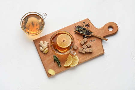 Composition with cups of tasty ginger tea and ingredients on white background