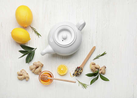 Composition with teapot of tasty ginger tea and ingredients on light wooden backgroundの写真素材