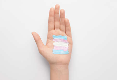 Painted transgender flag on palm against white backgroundの写真素材