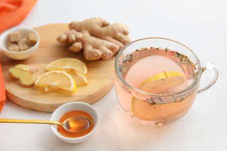 Cup of healthy tea with lemon, ginger and honey on tableの写真素材