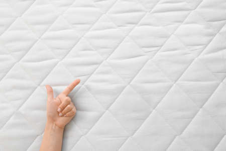 Female hand on soft orthopedic mattressの写真素材