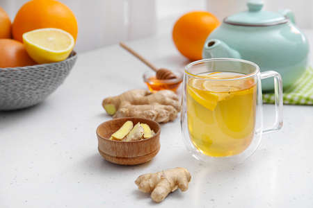 Cup of aromatic tea with lemon, ginger and honey on table
