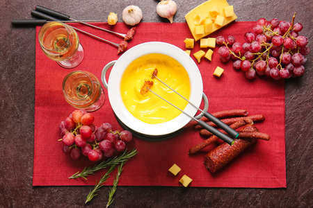 Cheese fondue and different snacks on dark backgroundの写真素材