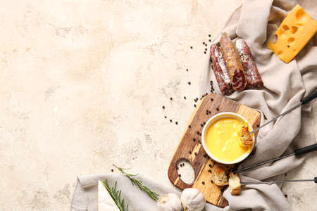 Cheese fondue and different snacks on light background