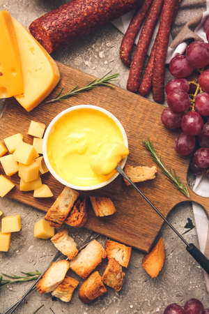 Cheese fondue and different snacks on grunge backgroundの写真素材