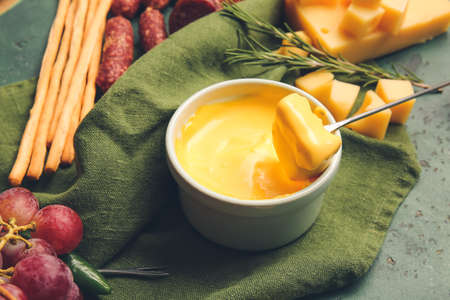 Stick with crouton dipped into cheese fondue on color backgroundの写真素材