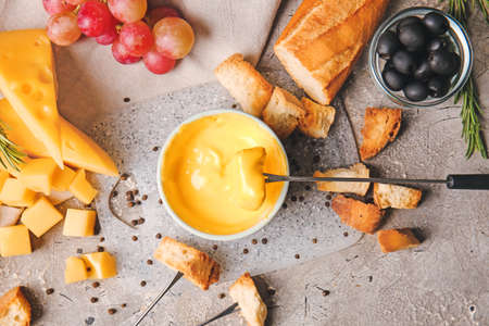 Cheese fondue and different snacks on grunge backgroundの写真素材