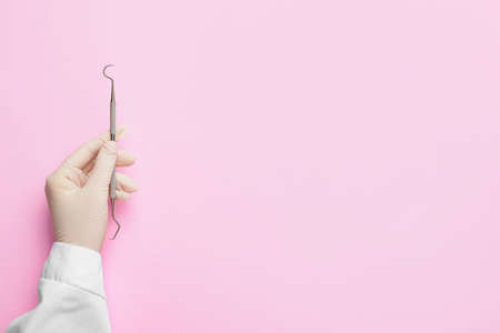 Dentist with instrument on color backgroundの写真素材