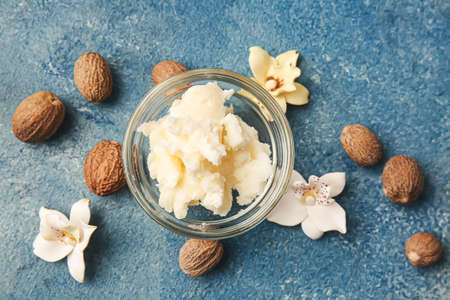 Bowl with shea butter and nuts on color backgroundの写真素材
