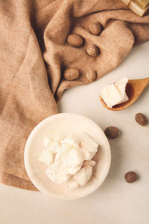 Plate with shea butter and nuts on light backgroundの写真素材