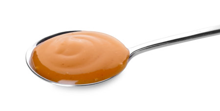 Spoon with tasty apricot jam on white backgroundの写真素材