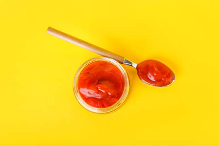 Jar and spoon with tasty ketchup on color backgroundの写真素材