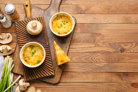 Ramekins with tasty julienne and ingredients on wooden backgroundの写真素材