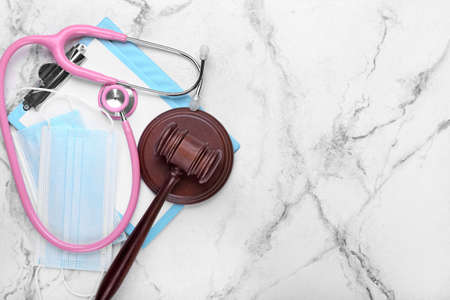 Judge gavel, masks and stethoscope on light background. Concept of health care reformの写真素材