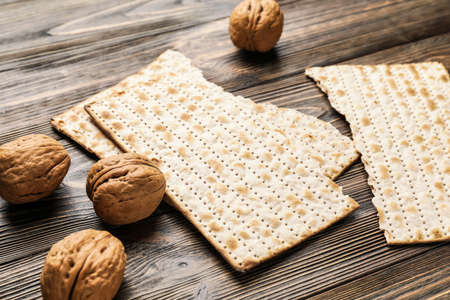 Jewish flatbread matza for Passover and walnuts on wooden backgroundの写真素材