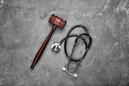 Judge gavel and stethoscope on gray background. Concept of health care reformの写真素材