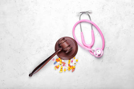 Judge gavel, pills and stethoscope on light background. Concept of health care reformの写真素材