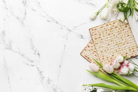 Jewish flatbread matza for Passover and flowers on light backgroundの写真素材