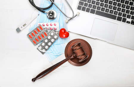 Judge gavel, laptop, heart, masks, pills and stethoscope on white background. Concept of health care reformの写真素材