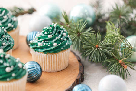 Tasty Christmas cupcakes and decor on tableの写真素材