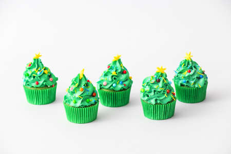Tasty Christmas cupcakes on light backgroundの写真素材