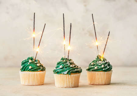 Tasty Christmas cupcakes on table