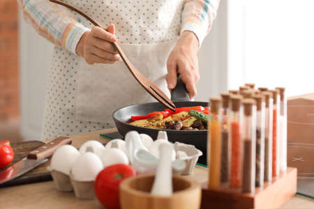 Young housewife cooking in kitchen at home