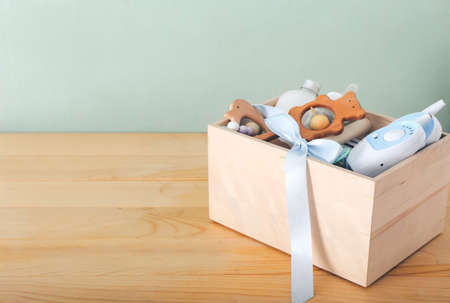 Box with gifts for baby on wooden backgroundの写真素材